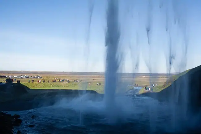 From behind the waterfall.