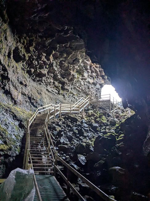 Walking down into the lava cave, looking back at the cave entrance